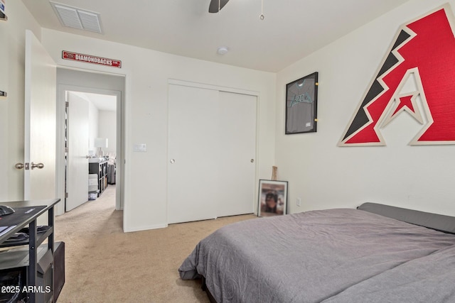 carpeted bedroom with ceiling fan and a closet