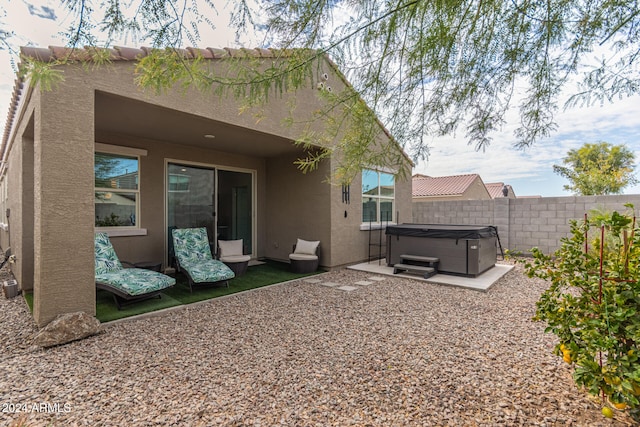 rear view of house with a patio area and a hot tub