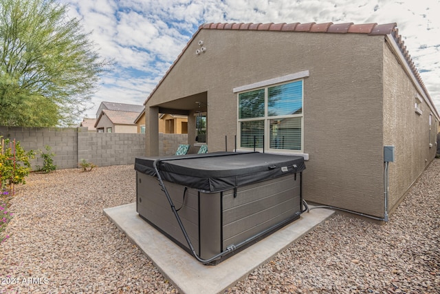 rear view of house featuring a hot tub