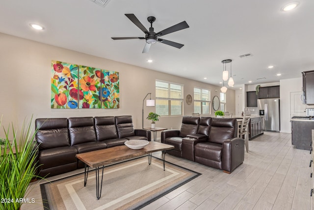 living room featuring ceiling fan and light hardwood / wood-style flooring