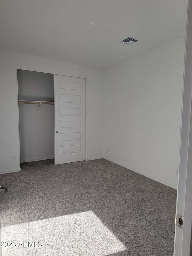 unfurnished bedroom featuring carpet and a closet