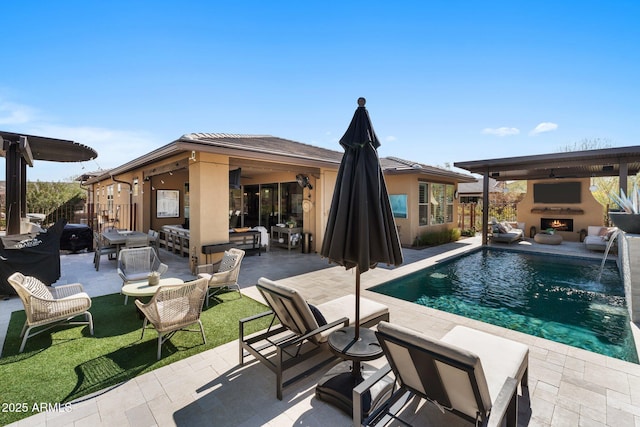 view of pool featuring a patio area, an outdoor living space with a fireplace, and pool water feature