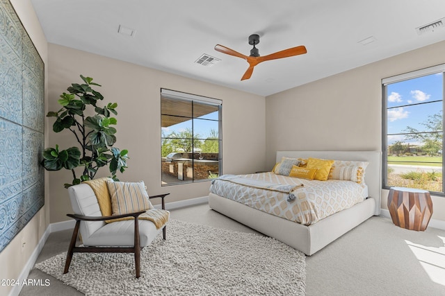 bedroom with multiple windows, ceiling fan, and carpet floors