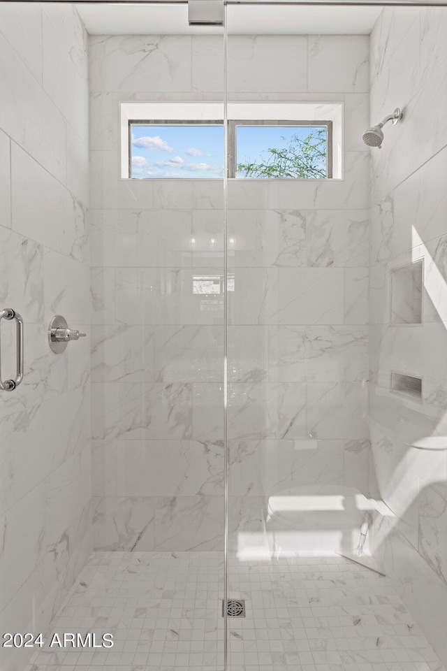 bathroom featuring a shower with door