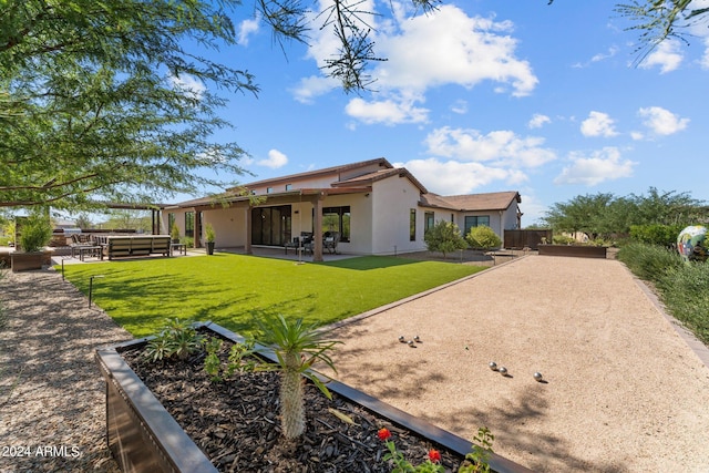 back of house with a yard and a patio