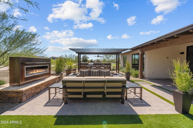 view of patio / terrace featuring an outdoor living space with a fireplace, a pergola, and ceiling fan