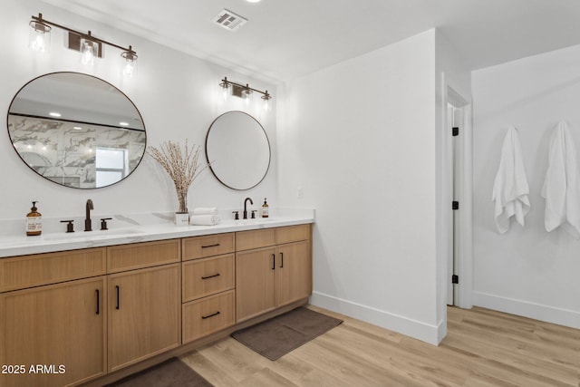 4842 E Surrey Ave, Scottsdale, AZ 85254 - bathroom featuring double vanity, wood finished floors, and a marble finish shower