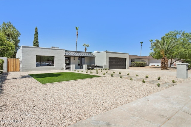4842 E Surrey Ave, Scottsdale, AZ 85254 - view of front of property featuring stucco siding, an attached garage, concrete driveway, a standing seam roof, and a metal roof
