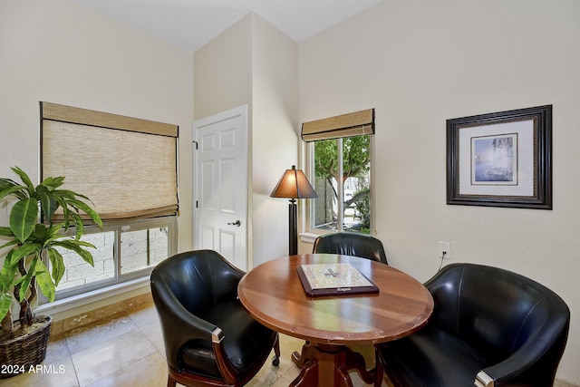 home office with a towering ceiling and light tile flooring