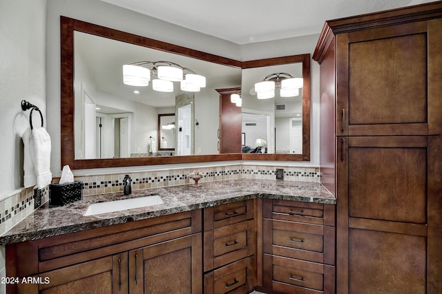 bathroom with tasteful backsplash and double sink vanity