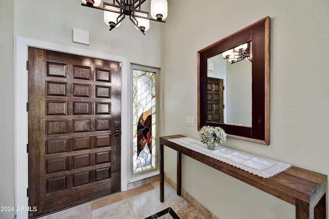 tiled foyer entrance featuring a notable chandelier