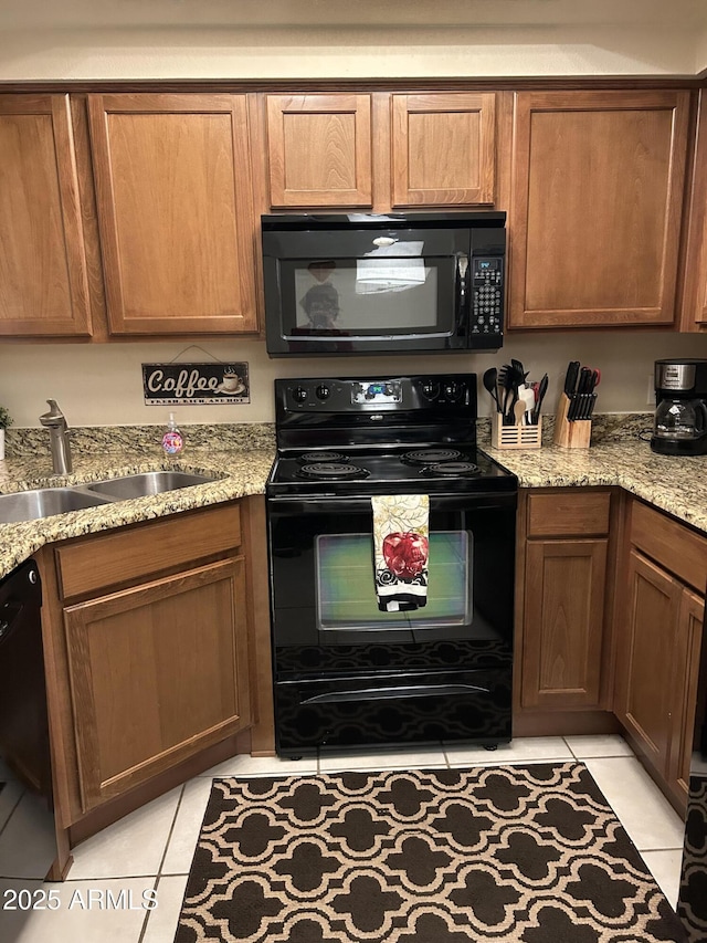 kitchen featuring black appliances, light tile patterned flooring, light stone counters, and sink