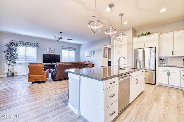 kitchen featuring appliances with stainless steel finishes, white cabinetry, hanging light fixtures, and ceiling fan