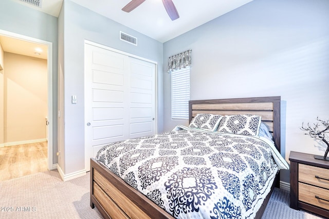 carpeted bedroom featuring ceiling fan and a closet