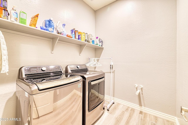 washroom with independent washer and dryer and light hardwood / wood-style flooring