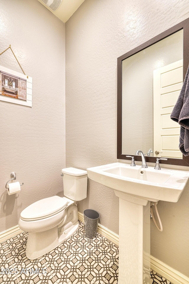 bathroom featuring tile patterned floors, toilet, and sink