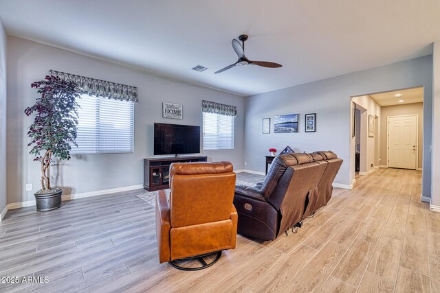 living room featuring plenty of natural light, ceiling fan, and light hardwood / wood-style flooring