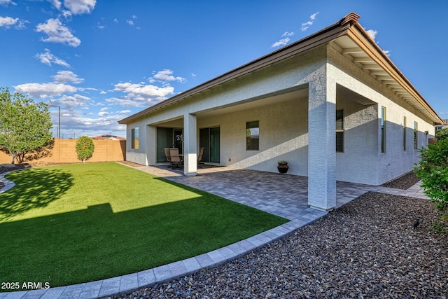 rear view of house featuring a lawn and a patio area