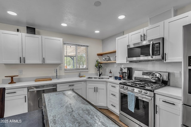 kitchen featuring sink, backsplash, white cabinetry, and stainless steel appliances