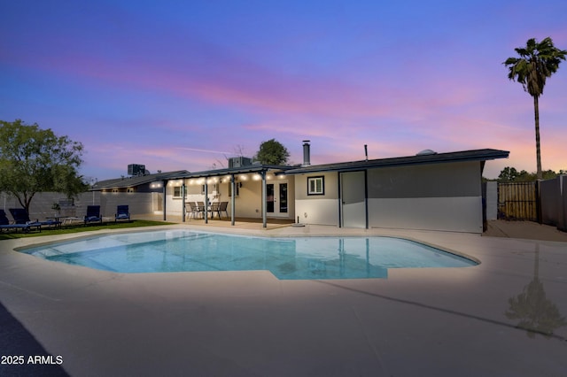 pool at dusk featuring a patio