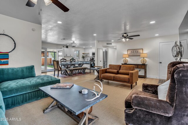 living room with ceiling fan and light wood-type flooring