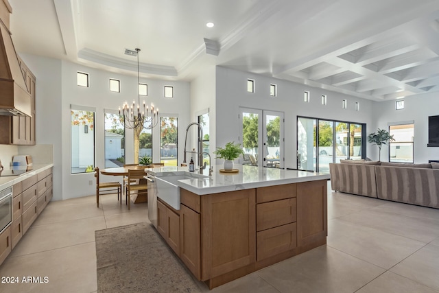 kitchen featuring hanging light fixtures, sink, a healthy amount of sunlight, and a center island with sink