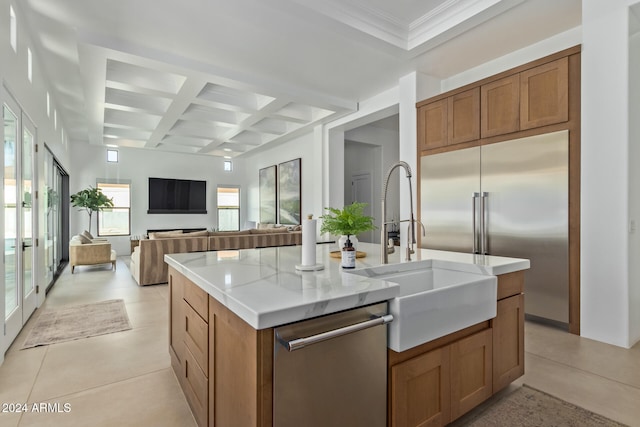 kitchen featuring beamed ceiling, sink, appliances with stainless steel finishes, a kitchen island with sink, and coffered ceiling