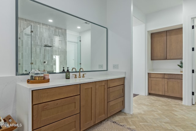 bathroom featuring vanity, parquet floors, and a tile shower