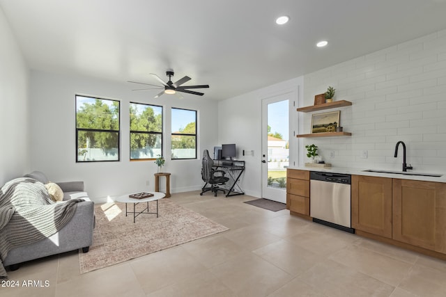 kitchen featuring dishwasher, sink, ceiling fan, light tile patterned flooring, and backsplash