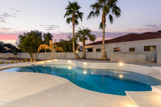 pool at dusk with a patio