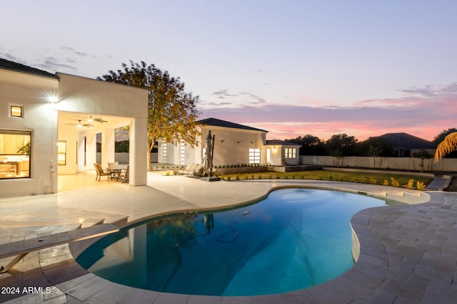 pool at dusk featuring a patio