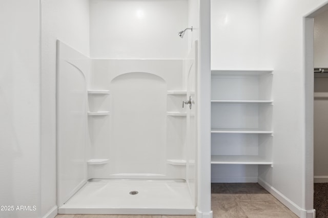12473 E Bahia Ct, Florence, AZ 85132 - bathroom with a walk in closet, baseboards, and a stall shower