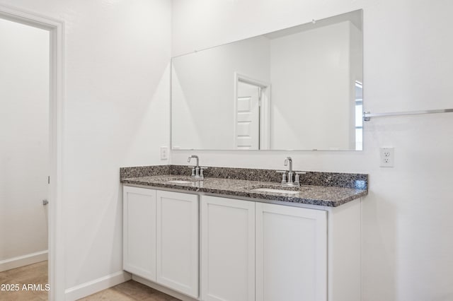 12473 E Bahia Ct, Florence, AZ 85132 - bathroom featuring double vanity, baseboards, and a sink