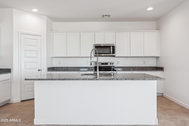 12473 E Bahia Ct, Florence, AZ 85132 - kitchen featuring visible vents, recessed lighting, dark stone countertops, appliances with stainless steel finishes, and a center island with sink