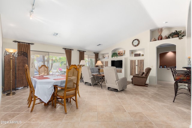 tiled dining space with vaulted ceiling and built in shelves