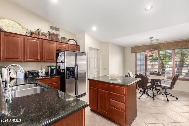 kitchen featuring a kitchen island, stainless steel refrigerator with ice dispenser, sink, vaulted ceiling, and pendant lighting