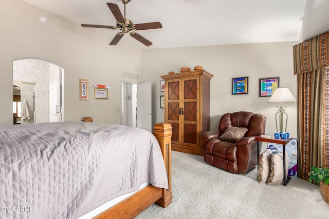 bedroom featuring ensuite bath, lofted ceiling, light colored carpet, and ceiling fan