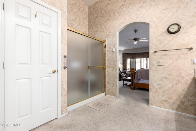 bathroom featuring a shower with door and ceiling fan