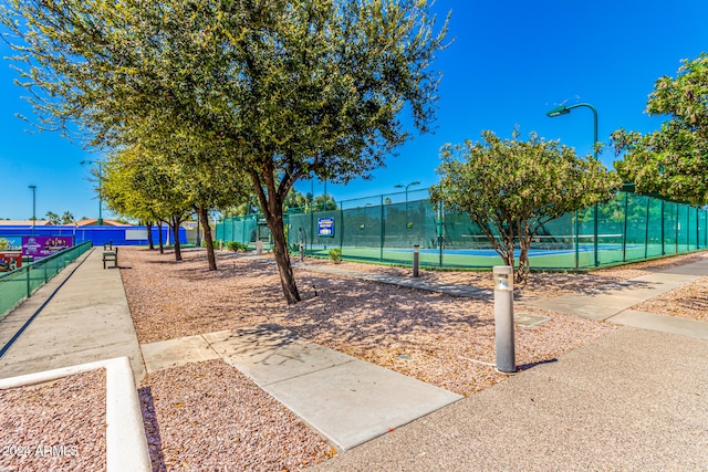 view of home's community featuring tennis court