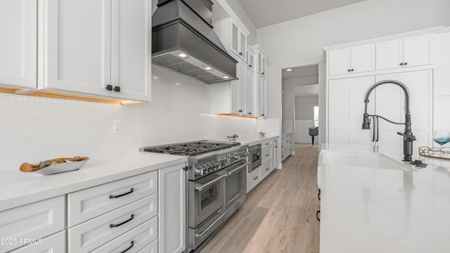 25228 S Star Dr, Queen Creek, AZ 85142 - kitchen with range with two ovens, light countertops, custom exhaust hood, and white cabinets