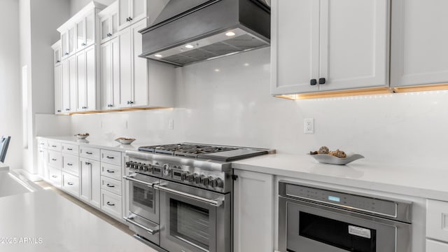 25228 S Star Dr, Queen Creek, AZ 85142 - kitchen featuring glass insert cabinets, range with two ovens, wall chimney exhaust hood, light countertops, and white cabinets
