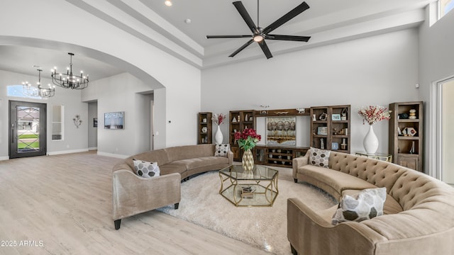 25228 S Star Dr, Queen Creek, AZ 85142 - living area with ceiling fan with notable chandelier, a high ceiling, arched walkways, and light wood-style floors