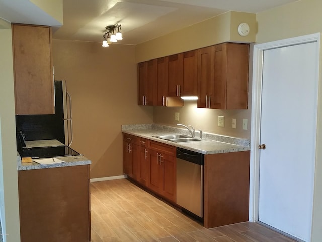 kitchen featuring stove, sink, dishwasher, light hardwood / wood-style floors, and fridge