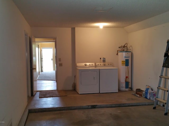 clothes washing area featuring washer and dryer, a textured ceiling, and gas water heater