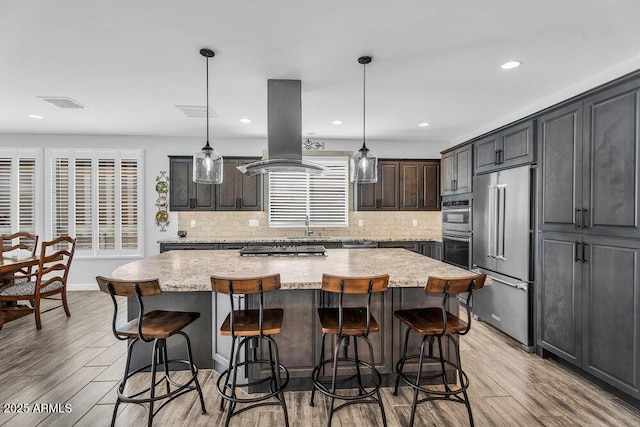 175 E Santa Lucia Ln, Queen Creek, AZ 85140 - kitchen with island range hood, visible vents, light wood-style floors, and stainless steel appliances