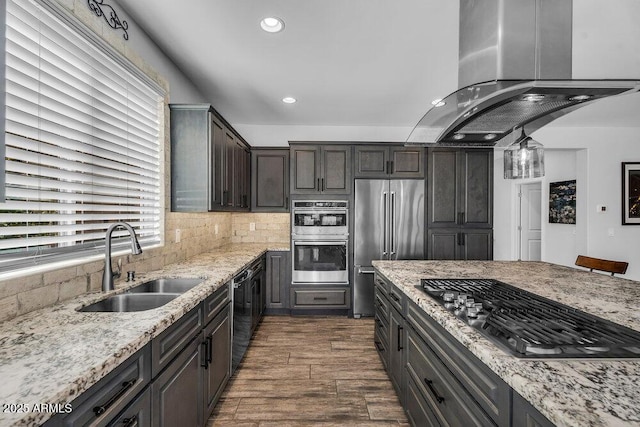 175 E Santa Lucia Ln, Queen Creek, AZ 85140 - kitchen with appliances with stainless steel finishes, island exhaust hood, a sink, light stone counters, and decorative backsplash