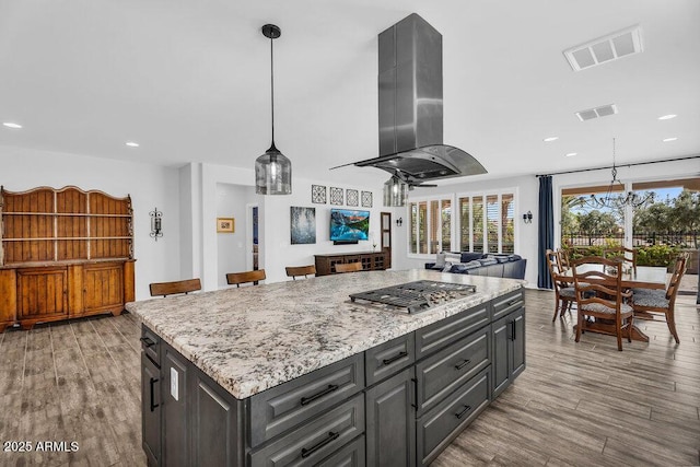 175 E Santa Lucia Ln, Queen Creek, AZ 85140 - kitchen featuring wood finished floors, island exhaust hood, stainless steel gas stovetop, and visible vents