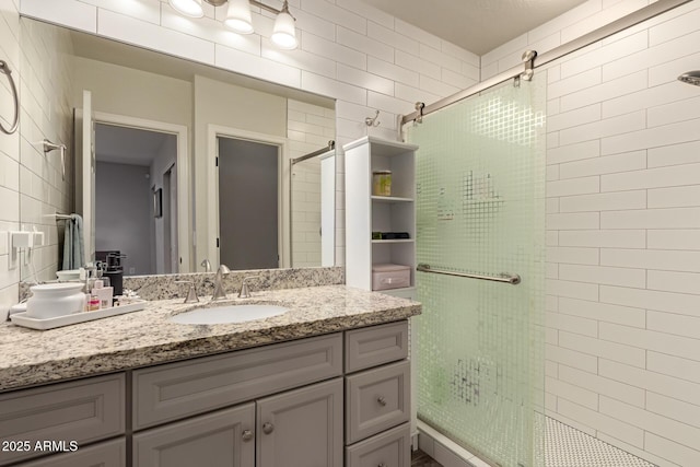 bathroom featuring vanity, a shower with door, and tile walls