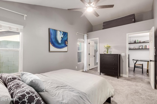 carpeted bedroom with multiple windows, ensuite bathroom, high vaulted ceiling, and ceiling fan