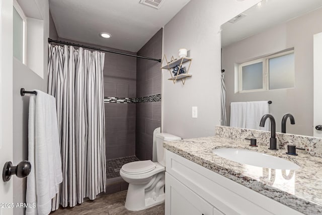 bathroom with vanity, hardwood / wood-style floors, a shower with shower curtain, and toilet